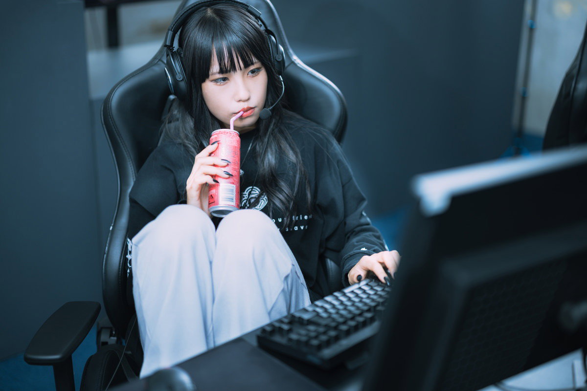 エナドリを飲みながらゲーミングチェアで休憩中のゲーマー女子の無料写真素材