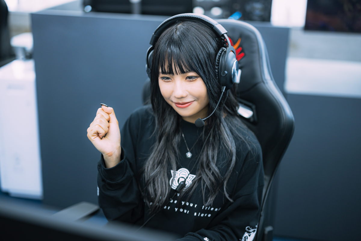 ヘッドセットを着けて笑顔で喜ぶ女性ゲーマーの無料写真素材