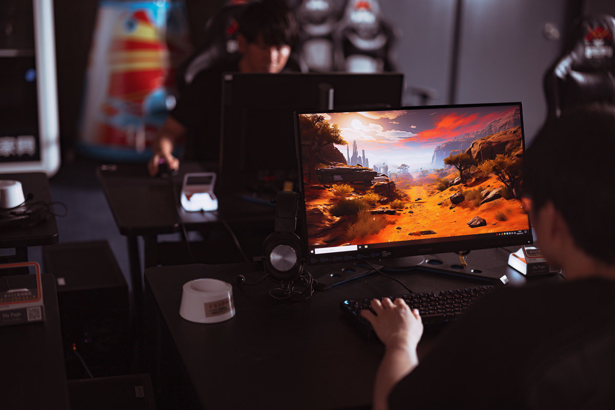 eスポーツエリアのゲーミングPCを使用してFPSゲームをプレイする選手の無料写真素材
