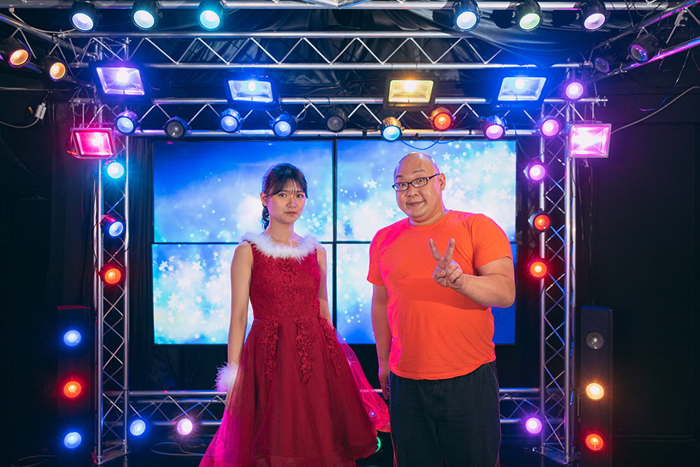 ステージ上でアイドルとツーショットを撮るファン