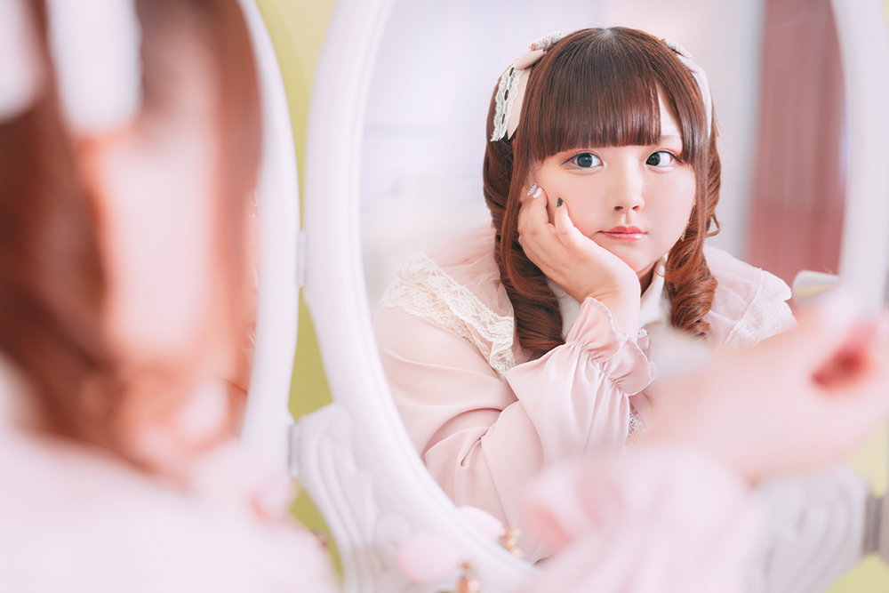 ミラーの中の自分を見つめるツインテ女子