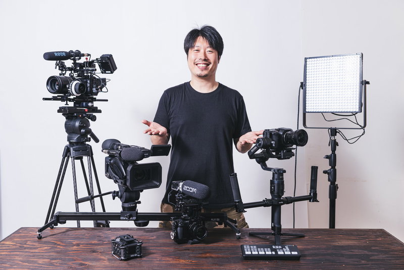 笑顔で動画機材を紹介するYouTuberの写真素材
