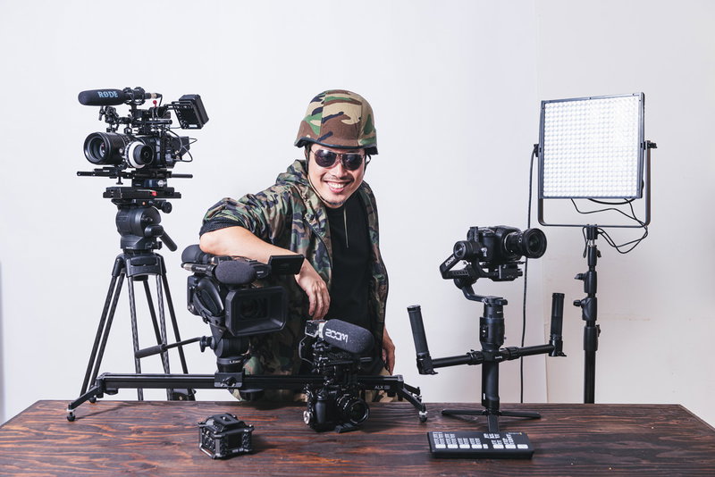 動画機材に囲まれてドヤる男性YouTuberの写真素材