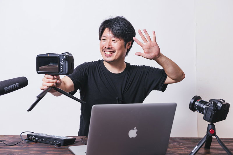 視聴者に笑顔を送るYouTuberの撮影風景の写真素材