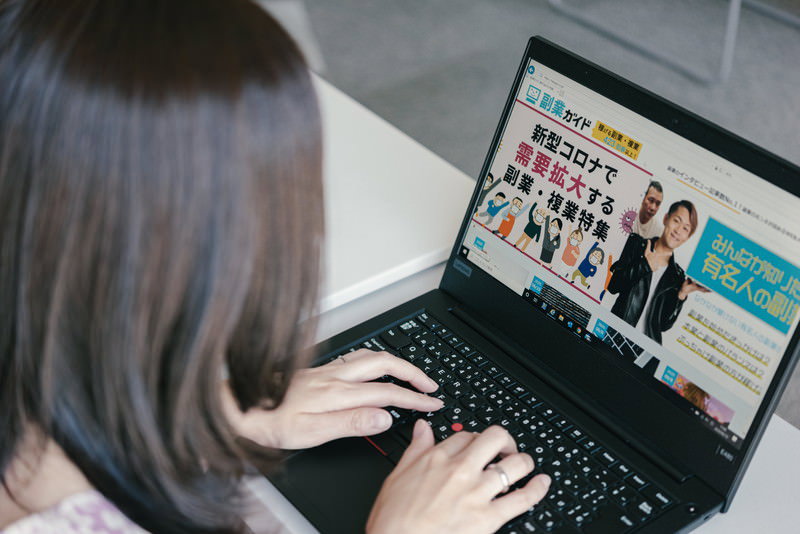 稼げる副業・複業をネットで調べる主婦の写真素材