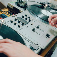 DJがミキサーとターンテーブルでレコードをミックスするの写真