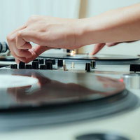 DJミキサーのつまみを調整してミックスする様子の写真