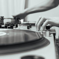 DJが機材でレコードをプレイするモノクロの写真