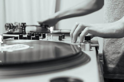 DJが機材でレコードをプレイするモノクロ