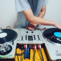 DJがターンテーブルでレコードをミックスしている様子の写真