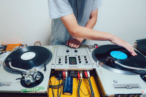 DJがターンテーブルでレコードをミックスしている様子