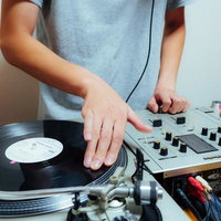 レコードを操作するDJがミキサーとターンテーブルを使うの写真