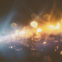 微細な光の粒が交差するボケ味のあるシーンの写真
