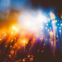 オレンジと青の光の交錯が作り出す輝きと光の粒の写真