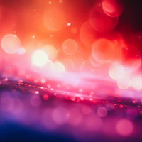 赤、ピンク、オレンジに輝く光の玉が流れる光景の写真