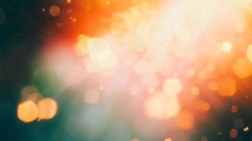 橙色と緑のボケが輝き広がる光のきらめき、玉ボケと光の粒が煌めく抽象背景