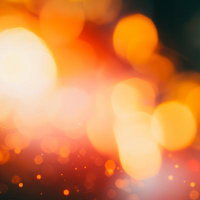オレンジの玉ボケと光の粒子の写真