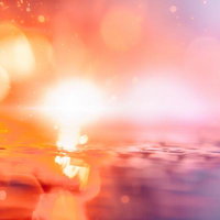 水面に浮かぶ輝く光の粒がきらめく幻想的な光景の写真