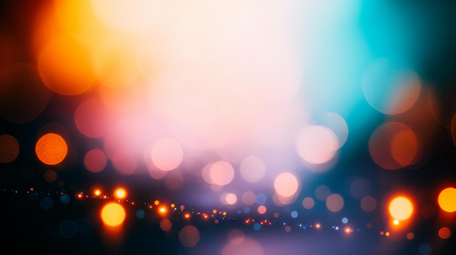 オレンジ色と青色のグラデーションの中で、ぼやけた光の輪がきらめいている画像