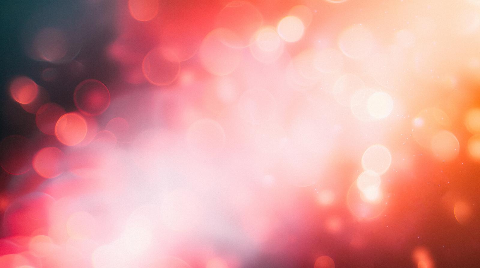 赤やピンクの光の輪が重なり合い、ぼんやりときらめく抽象的な光の景色