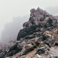ガスと霧に包まれる焼岳山頂の巨大な岩と雲海の写真