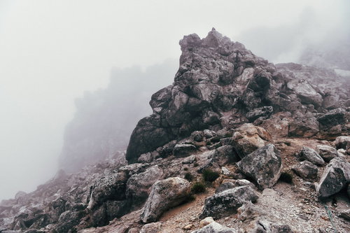 ガスと霧に包まれる焼岳山頂の巨大な岩と雲海