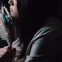 造花のスワッグを手に持つ黒髪の女性の横顔の写真