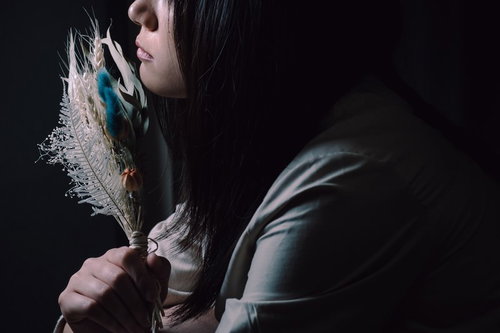 造花のスワッグを手に持つ黒髪の女性の横顔