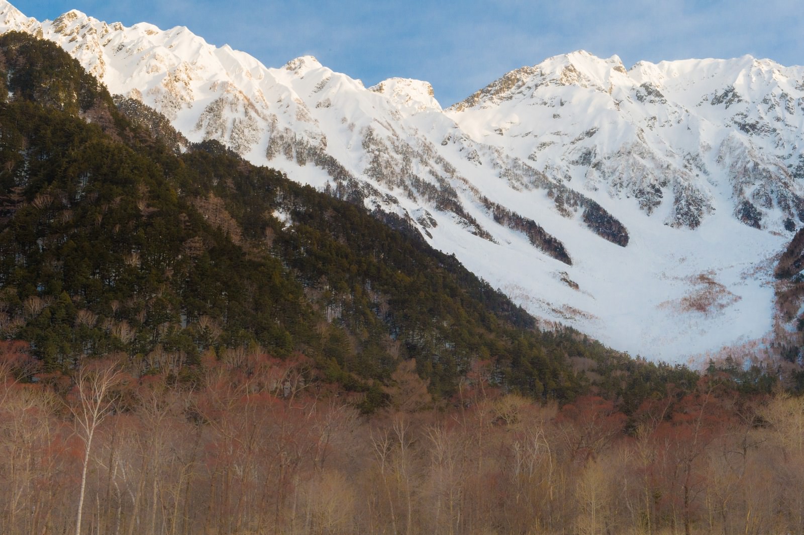 冬の上高地から見上げる雪化粧した穂高連峰と青空