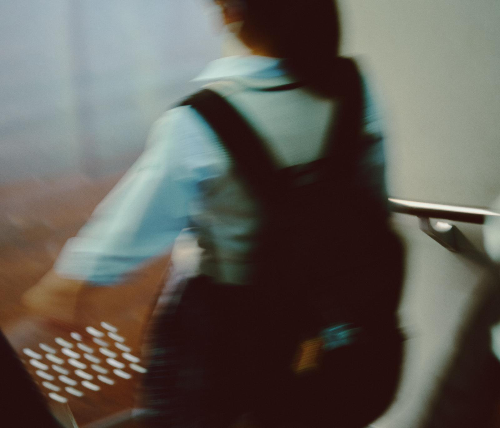 リュックを背負った女子学生が地下鉄内を歩いている通学風景