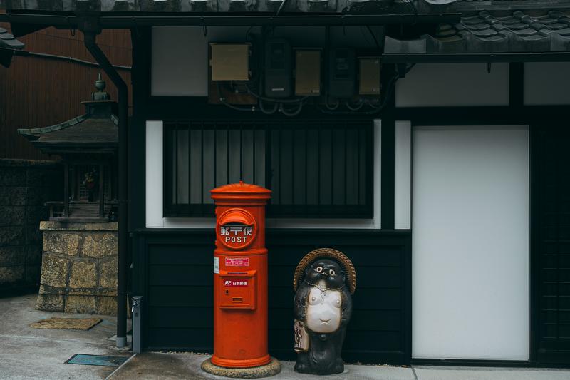 石畳の通りに立つ古くて赤い郵便ポストの写真素材 - フリー素材ぱくたそ