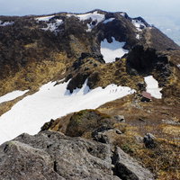 日本百名山・岩木山の雪渓を歩く登山者たちの写真