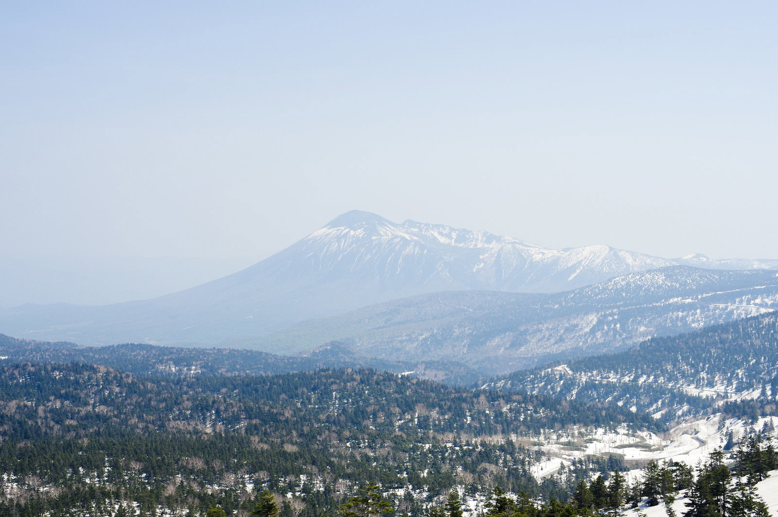 八幡平から見た雪化粧した岩手山と青空、手前に雪の森林
