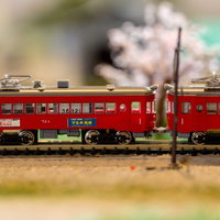 ジオラマを走る赤い電車の模型、精巧な田園風景ジオラマの写真