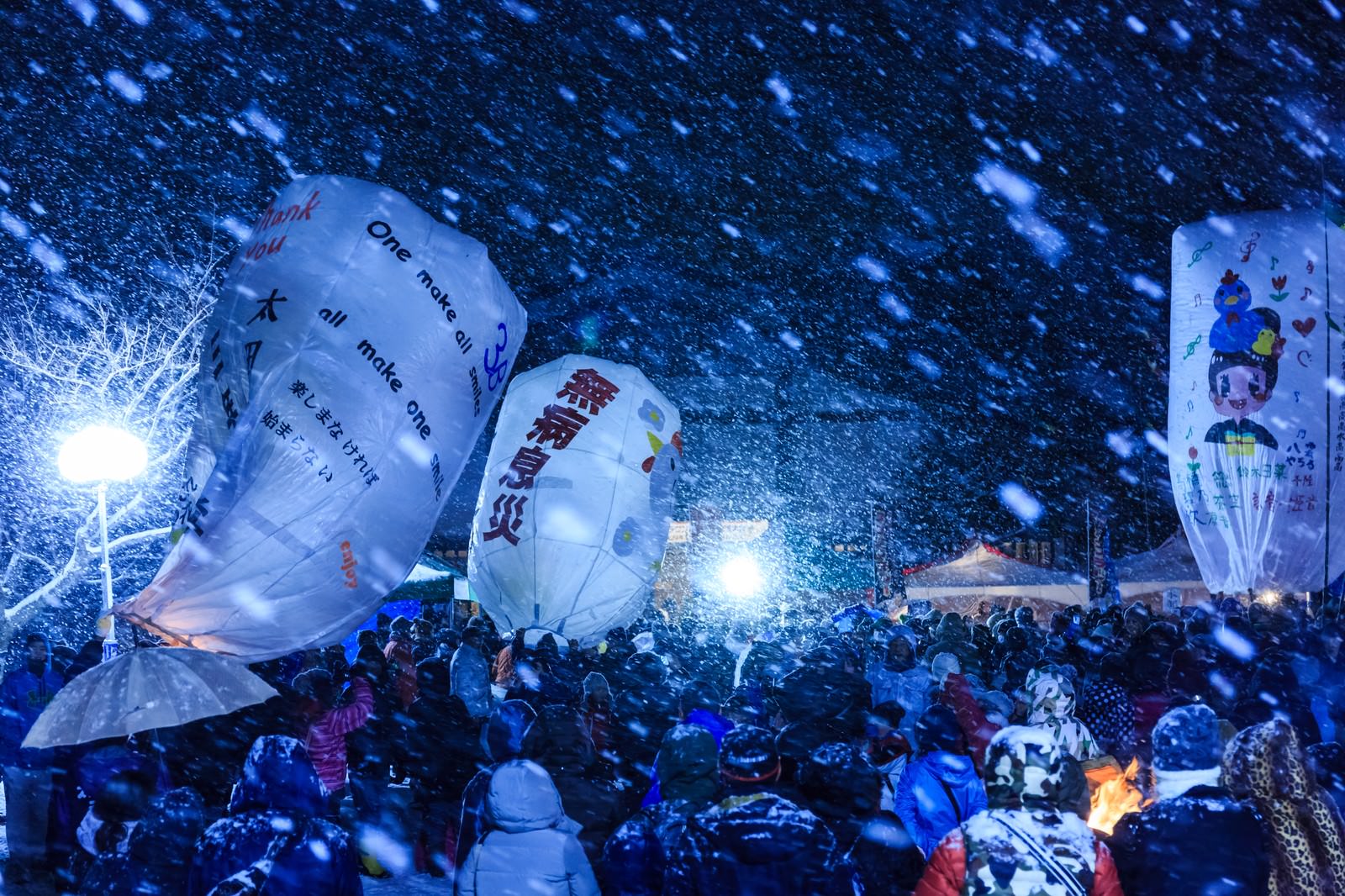 大雪の夜に浮かぶ紙風船と群衆