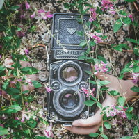 ローライフレックスを持った女性の手と白い花の写真