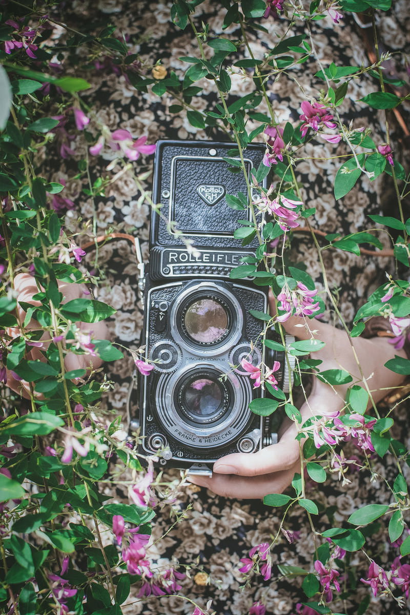 花に囲まれて置かれたローライフレックスのフィルムカメラ