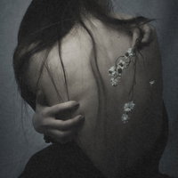 絶望にくれ頭を抱える女性の背中と心身の不調の写真