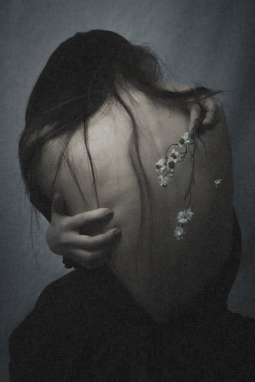 絶望にくれ頭を抱える女性の背中と心身の不調