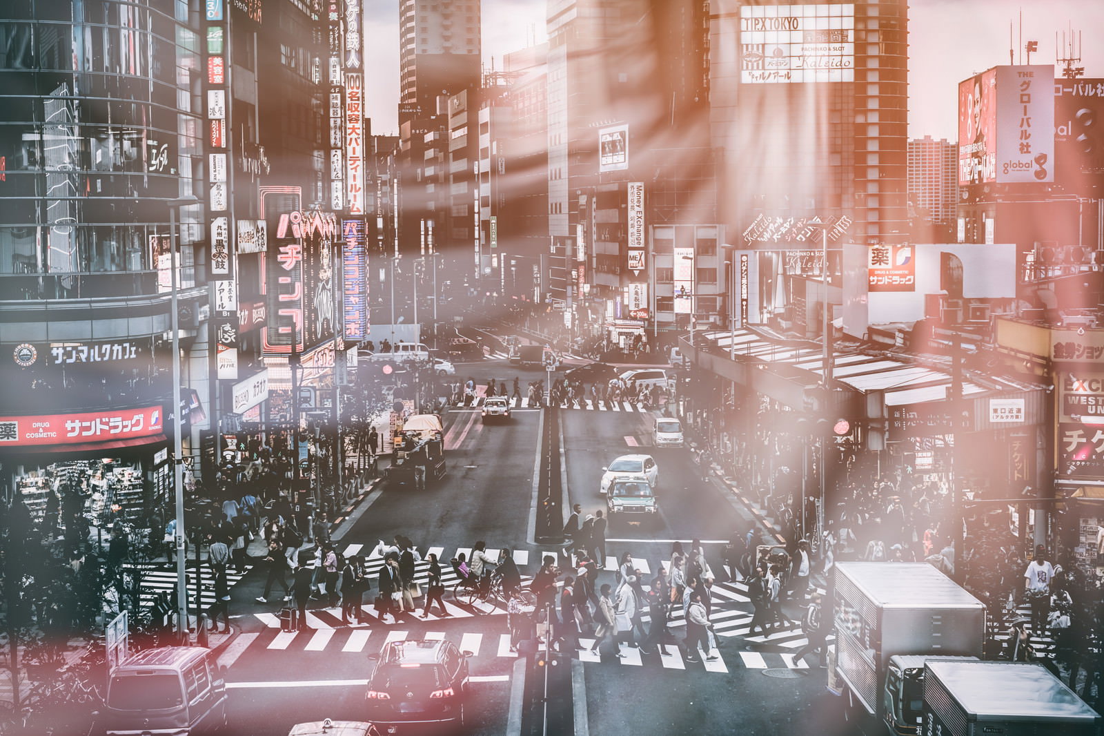 夕日の逆光の中、横断歩道を渡る多くの人々のシルエットが多重露光で重なり合っている