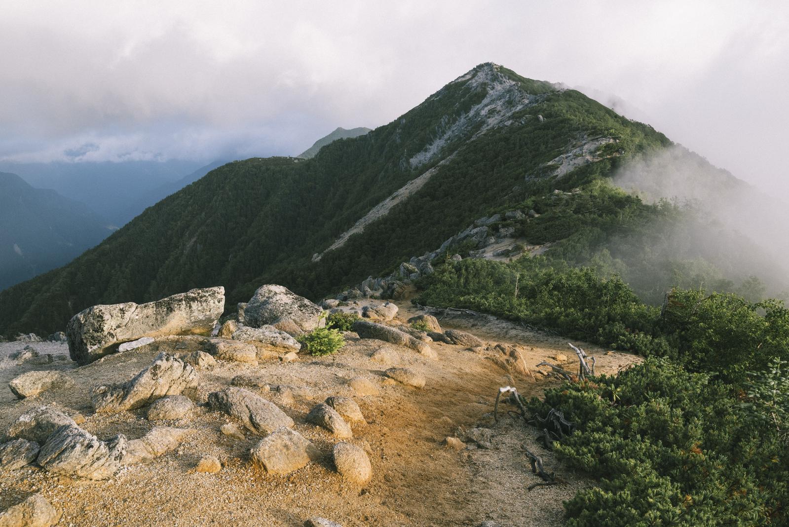 霧の中に見える鳳凰三山観音岳の登山道と岩場