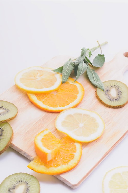 白いまな板の上にカットされたレモンとキウイ