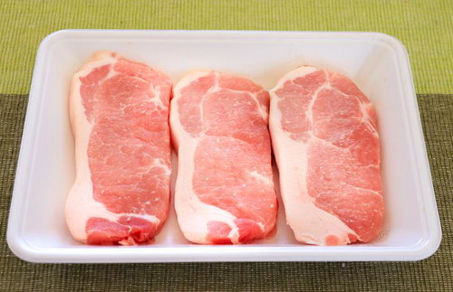 トレーに並んだ厚切り豚ロース肉の写真