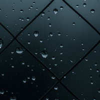 薄暗い窓ガラスに付着した水滴の写真