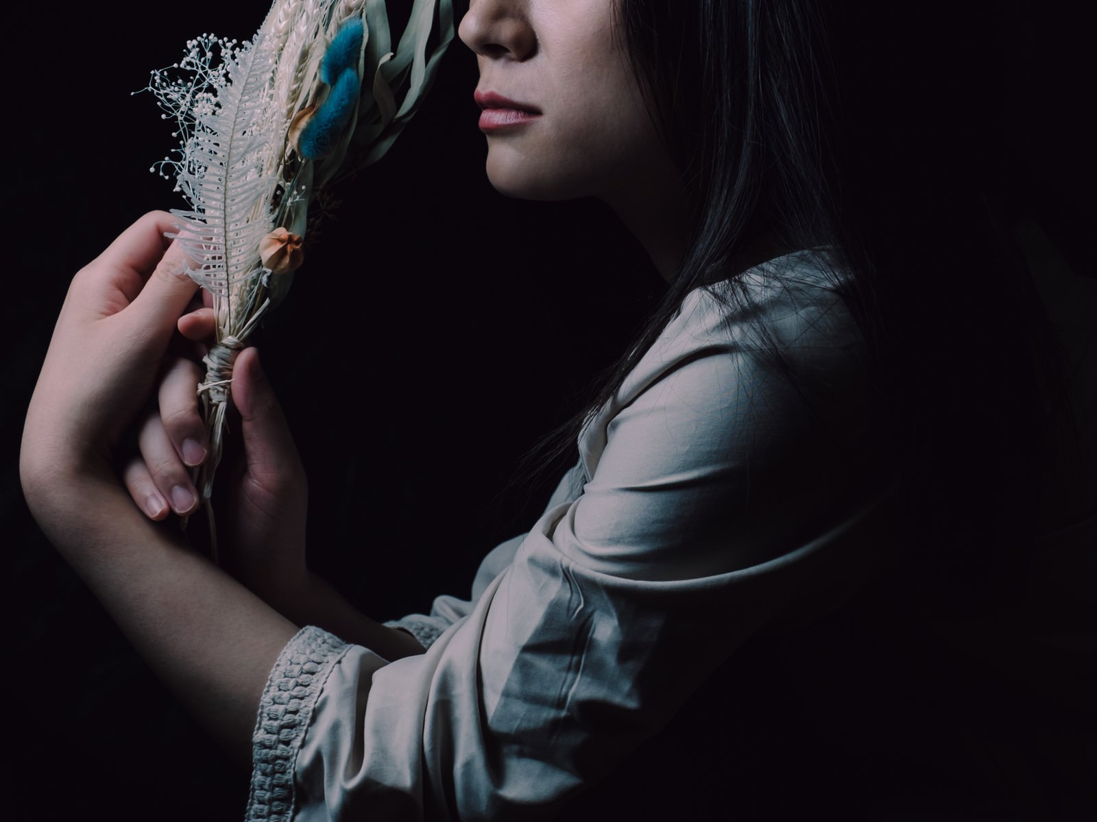 手に持ったスワッグを頬に寄せている女性の横顔