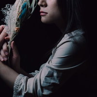 手に持ったスワッグを頬に寄せる女性の横顔の写真