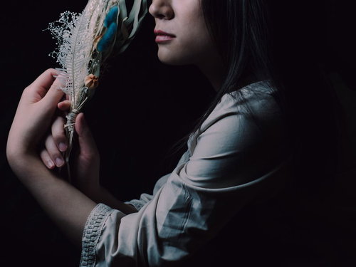 手に持ったスワッグを頬に寄せる女性の横顔