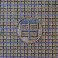 グレーの金属製マンホールの蓋のテクスチャーの写真