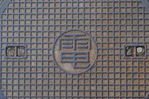 グレーの金属製マンホールの蓋のテクスチャー