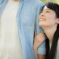 彼の腕を抱きしめる。幸せデート真っ最中の屋外でのカップルの写真